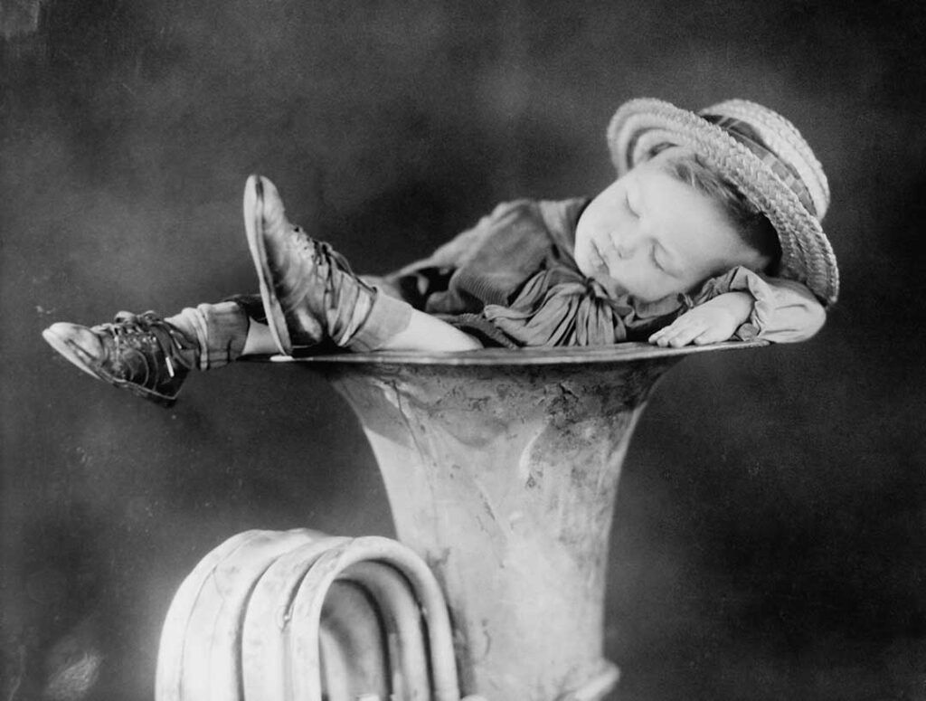 Kid asleep in a tuba